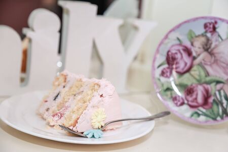 A piece of cake on a plate next to the inscription Family.の写真素材