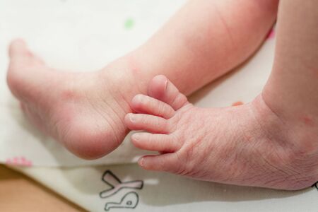 Newborn baby's feet in parents' hands.