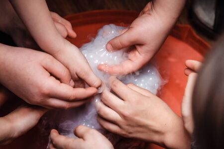 Baby hands in foam. Children play with foam.