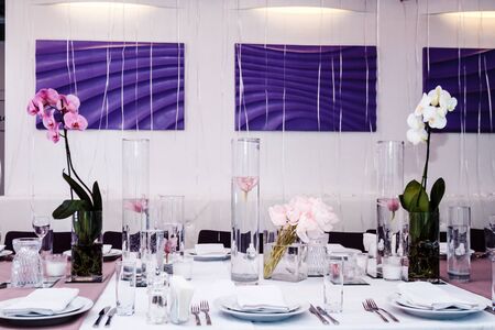 Serving tables in a restaurant with peonies and orchids.
