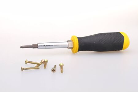 Furniture screws with a screwdriver on a white background. Close-up.の写真素材