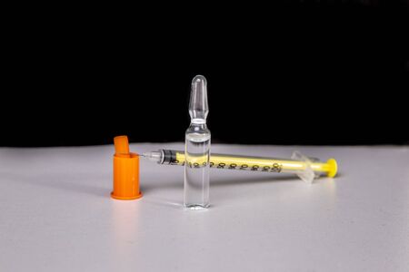 Insulin syringe with vial on a light tableの写真素材