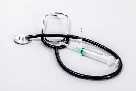 Phonendoscope and syringe on a white backgroundの写真素材