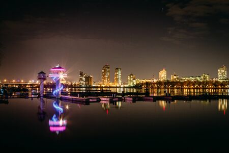 Lighthouse in the background of the night cityの写真素材