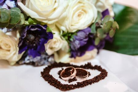 Wedding rings against the background of a bouquet of rosesの写真素材