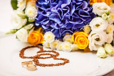 Wedding rings against the background of the bride's bouquetの写真素材