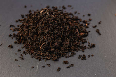 a slide of black tea on a stone background