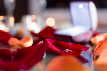 Gold ring, wedding ring in red box and, red heart on white-red background with beautiful bokeh. The...