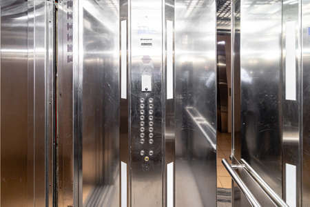 The elevator entrance is in modern office with marble wall. Lift transportation floor to floors with push switch for up and downの写真素材