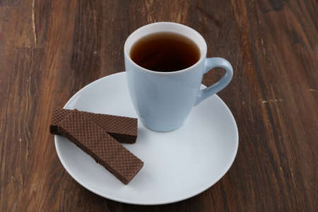 Chocolate Wafer on Wooden Plate, Served with Tea, Copy Space.の写真素材
