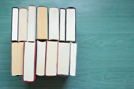 Overhead view of several books facing each other on a table. Background with copyspace.