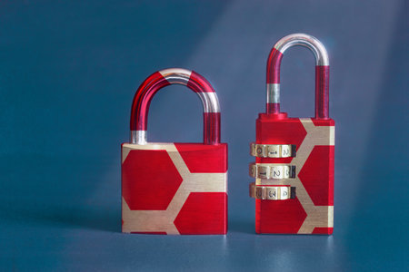 A close-up of a modern image of two vintage padlocks with a colorful original design on a textured painted studio background with copy space. Security concept.の写真素材