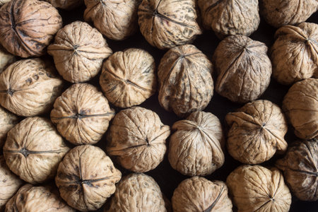 Close-up top view of whole walnuts in shells, highlighting natural beauty, and texture. Unique...