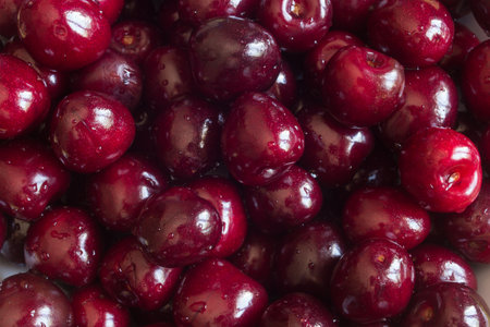 An extreme close-up of a bunch of fresh washed cherries in an overhead view, showing their details...