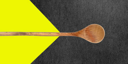 Topview of Cooking Wooden Spoon on Yellow and Dark Backgroundの写真素材