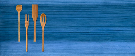 Topview of Set Cooking Wooden Utensils on Blue Table Backgroundの写真素材