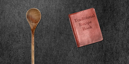 Topview of Wooden Cooking Spoon and Recipe Book on Dark Backgroundの写真素材