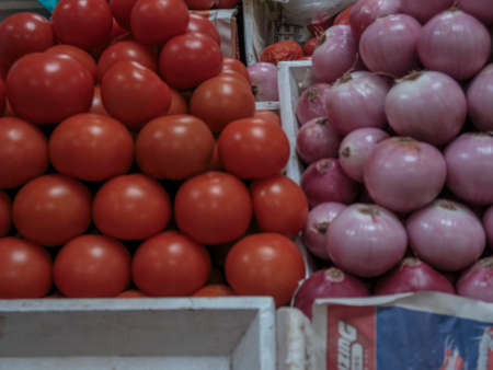 Onions and tomatoes ready for sale on a marketの写真素材