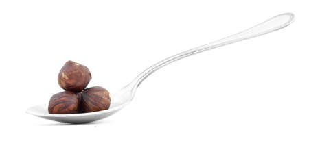 Hazelnuts in spoon isolated on white backgroundの写真素材