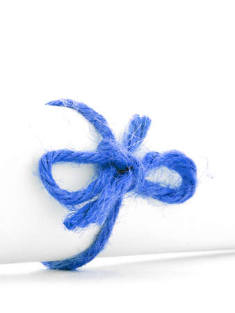 Handmade blue string node tied on white message scroll, isolatedの写真素材
