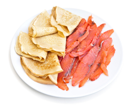 Russian pancakes with red fish on the white plate - isolated on the white backgroundの写真素材