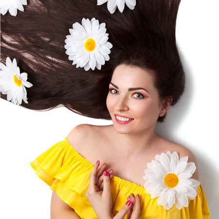 Beautiful Summer Brunette Girl in Yellow Dress with Camomiles  Healthy Long Dark Hair, Clear Young Skin, White Teeth の写真素材