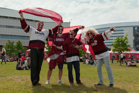 MINSK, BELARUS - May 17, 2014  ICE HOCKEY WORLD CHAMPIONSHIP, MINSK-ARENA, The hockey fans from Latvia with national flags in the uniform of a national team of Latviaのeditorial素材