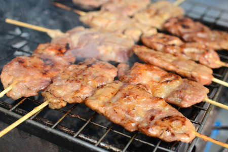 The meat is preparing on the grill, street food in Bangkok, Thailandの写真素材