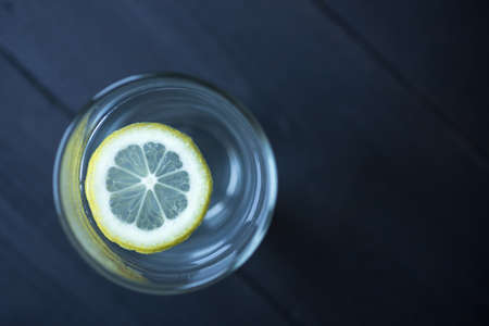 A slice of lemon in a glass of waterの写真素材
