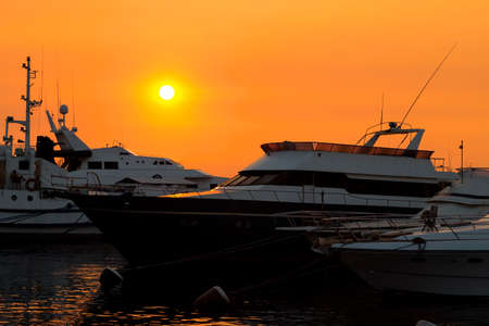 Yachts in orange sunsetの写真素材