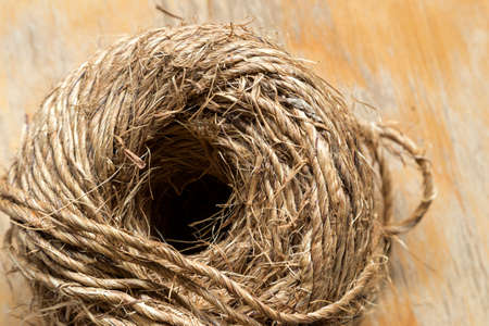 Skein ball of jute twine on wooden background, close up, macro