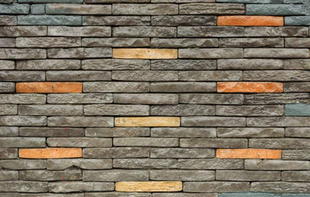 Texture of the brown and grey wall made of stone tile bricks