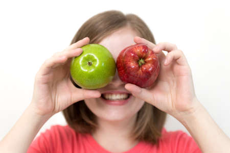 Portrait of smiling caucasian woman girl with green and red apples in her hands. Healthy lifestyle, fruit vegetarian diet.の写真素材