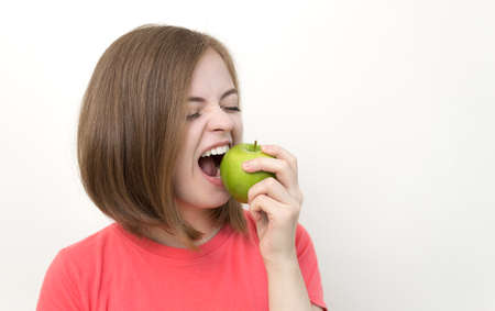 Portrait of caucasian woman girl biting green apple. Healthy lifestyle, fruit vegetarian diet.の写真素材