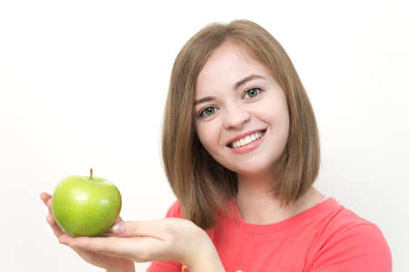 Portrait of smiling caucasian woman girl with green apple in her hand. Healthy lifestyle, fruit vegetarian diet.の写真素材