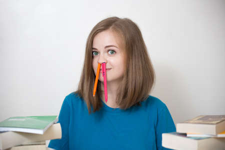 Young caucasian smiling girl woman with many books study at school or university, funny face