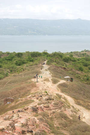 Tourists walking hiking trekking tour trail to Taal volcano, Batangas, Philippinesの写真素材