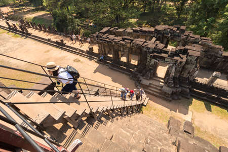 Cambodia, Angkor Wat, Siem Reap - January 30, 2017: Tourists climb the stairs to the pyramid temple,...