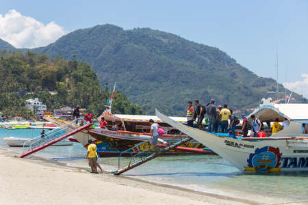 Puerto Galera, Sabang, Philippines - April 4, 2017: Passengers tourists on boats in  White beach.のeditorial素材