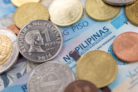 Cash banknote of one thousand Philippines peso and coins paying bills, payment or bribe, salary, close up macroの写真素材