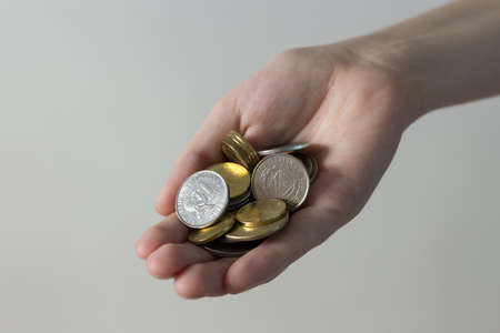 Hand holding giving Philippines peso coins paying bills, payment procedure or bribe, salary, povertyの写真素材