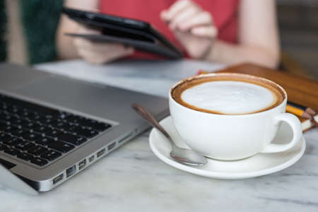 Coffee cup and laptop for business on table, close up macroの写真素材