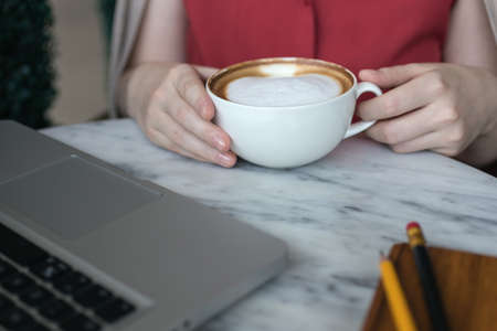 Woman's handswith coffee cup and laptop for business on table, close up macroの写真素材