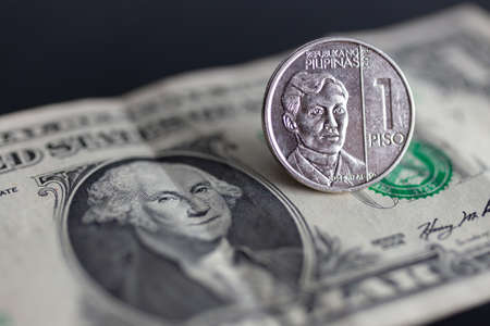 Cash banknote of one US dollar and one peso Philippine coin. Money exchange, currency