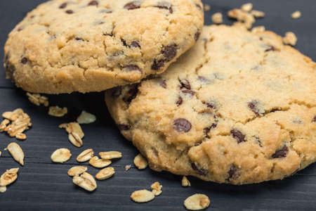 Oatmeal raisin cookies on black surface background, close up macro