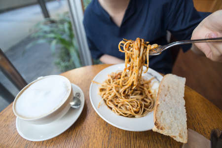 Woman eating Itlian spaghetti pasta with fork, close up macroの写真素材