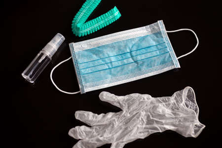 A surgical face mask, gloves and alcohol during the  quarantine. Black backgroundの写真素材