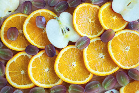 Close up of orange, apple and grape cut slices composition. Healthy fruit vegetarian snack conceptの写真素材