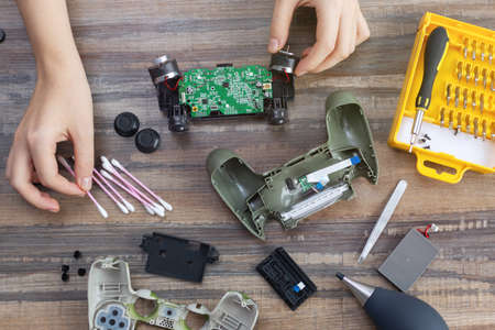 Toronto, Canada - Mat, 23,2020: Flat lay of hand disassemble game controller repairing, cleaning or diagnostic.のeditorial素材