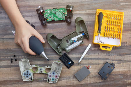 Toronto, Canada - Mat, 23,2020: Flat lay of hand disassemble game controller repairing, cleaning or...